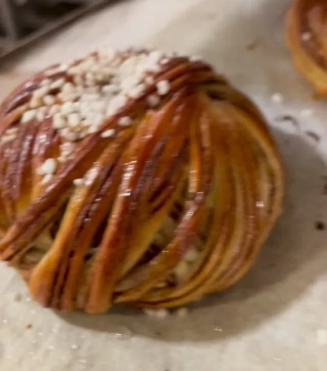 A twisted cinnamon bun with pearl sugar, straight from the tray