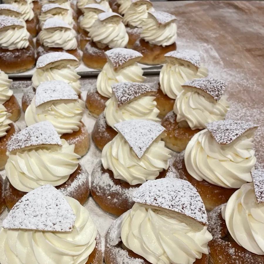 A tray of semlor — cream-filled cardamom buns dusted with icing sugar